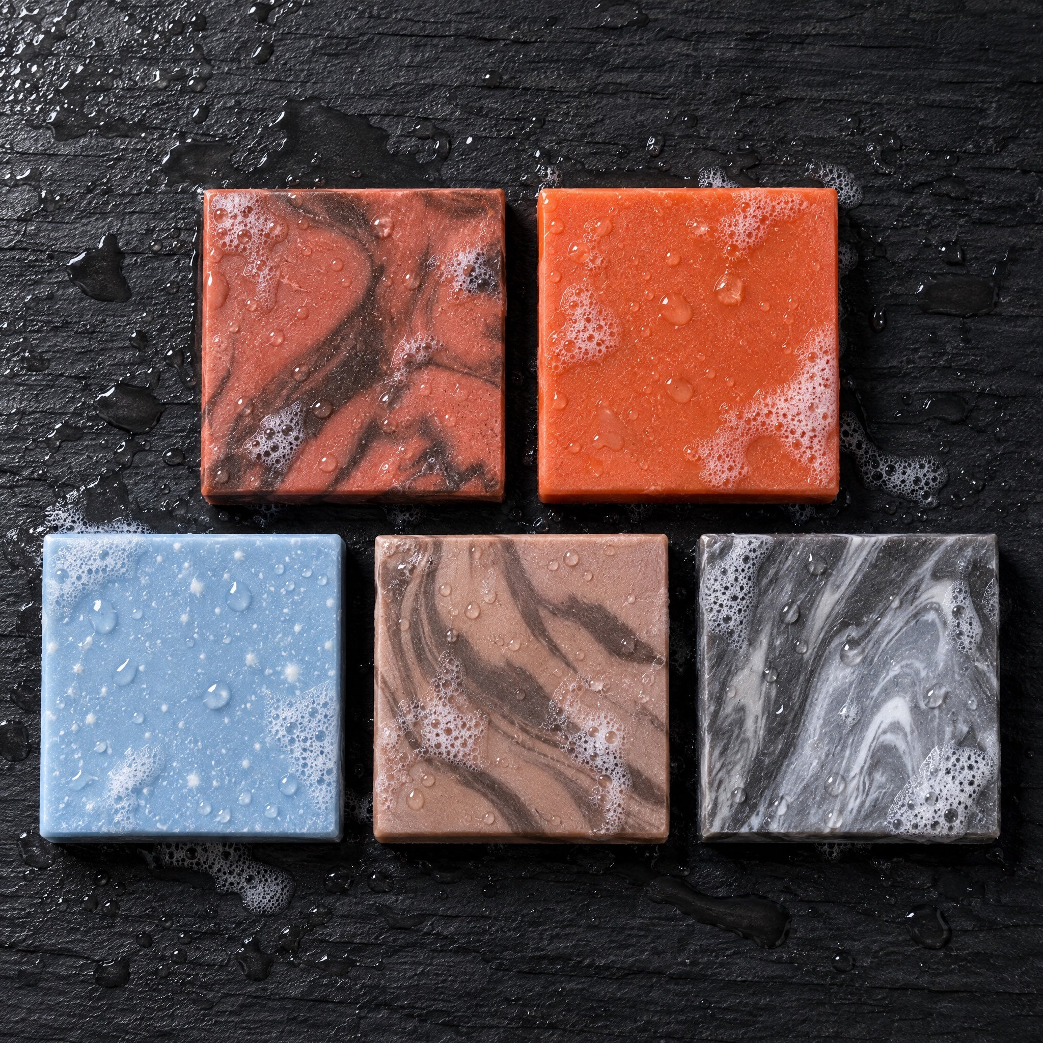 Overhead view of the five Pioneer Tallow soap bars on wet slate