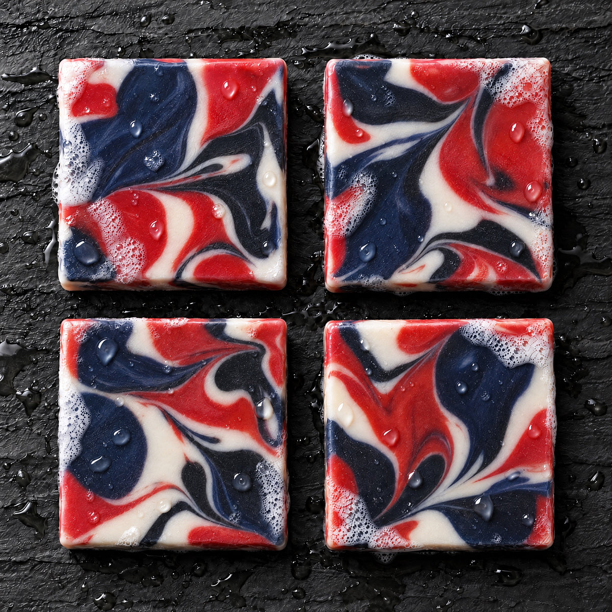Overhead view of four 250 Proof red white and blue marbled soap bars on wet slate